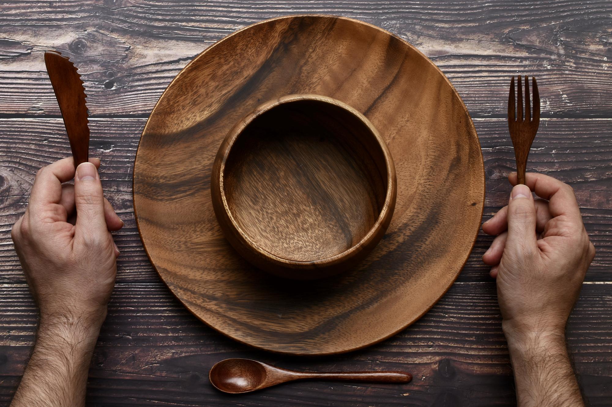 hands plating a rustic dish in a minimal kitchen